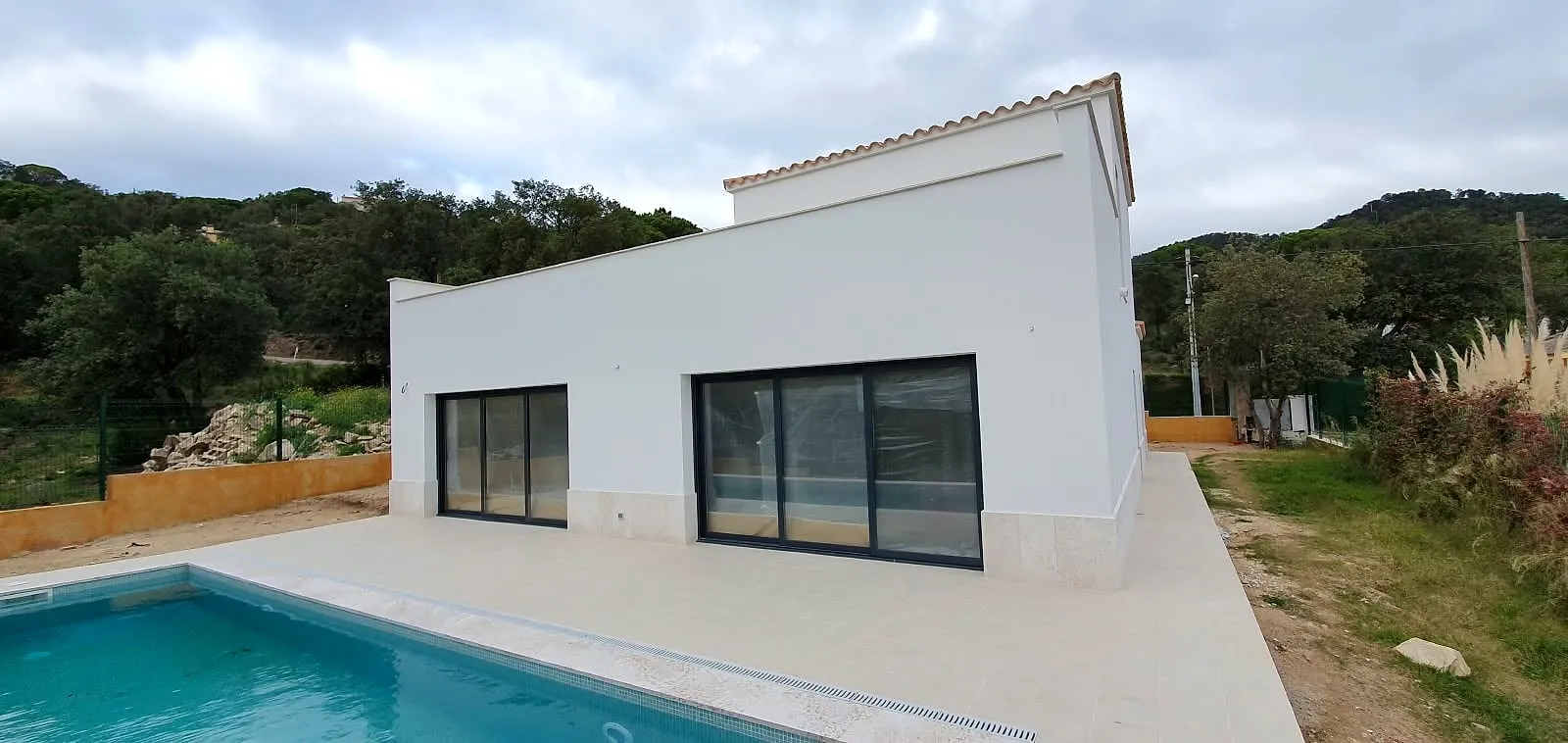 Casa blanca de una planta con piscina