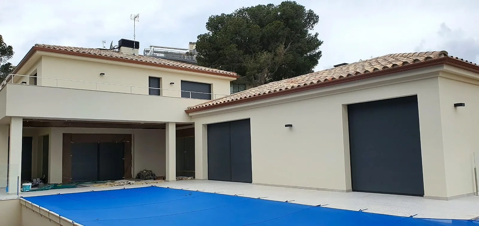 Casa con fachada crema, garajes antracita y piscina