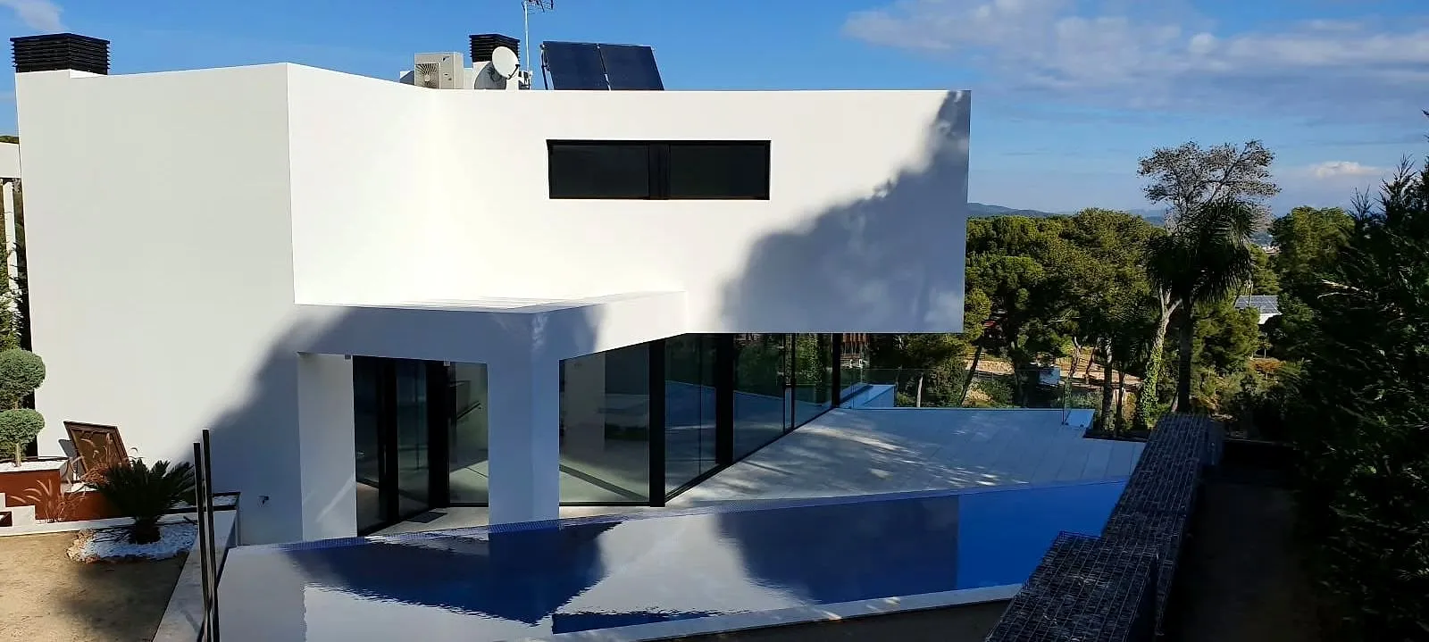 Fachada blanca con voladizo en una casa de obra nueva