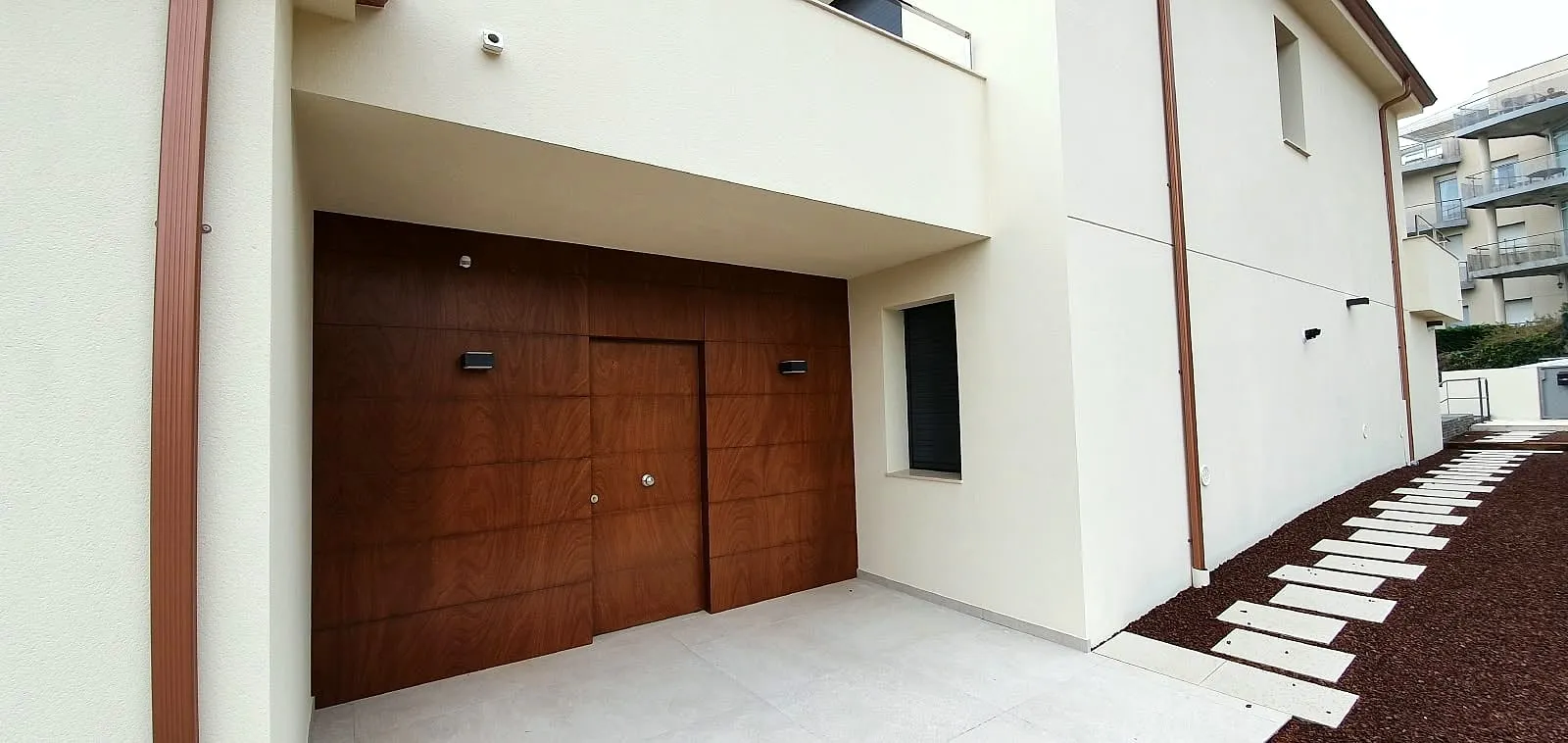 Puerta de garaje de madera en una fachada blanca