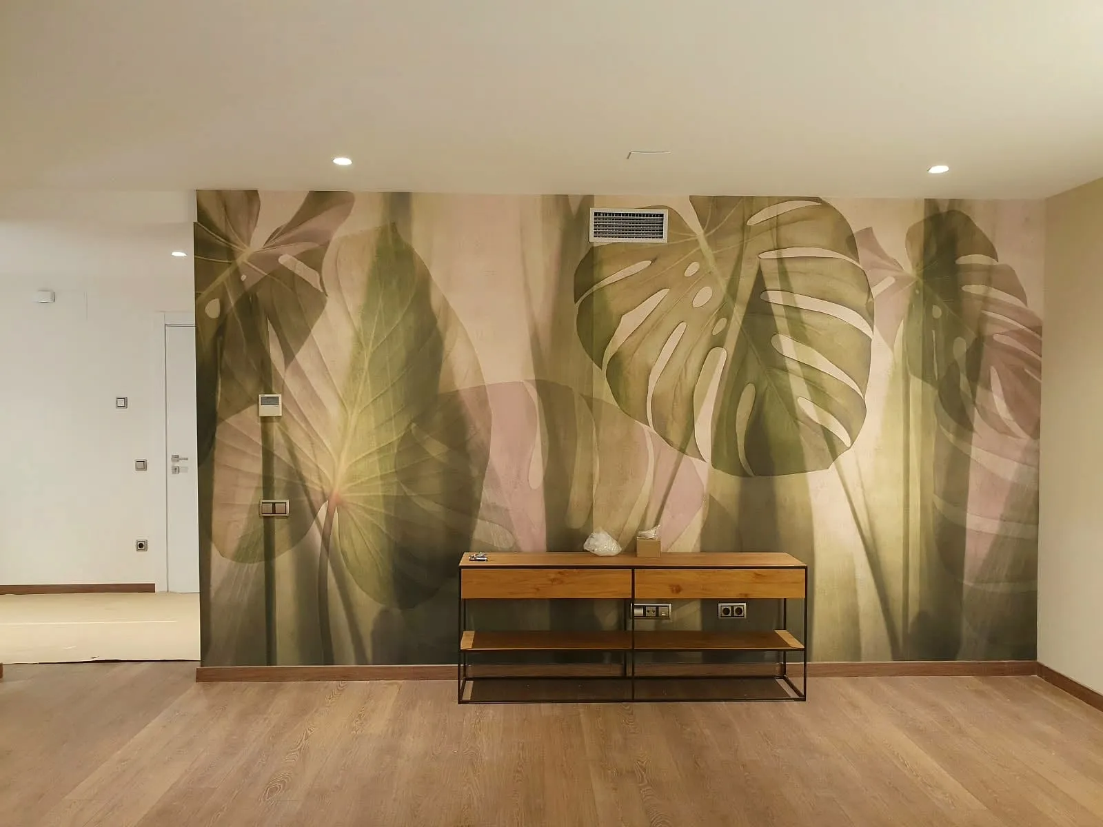 Recibidor con papel pintado de hojas tropicales