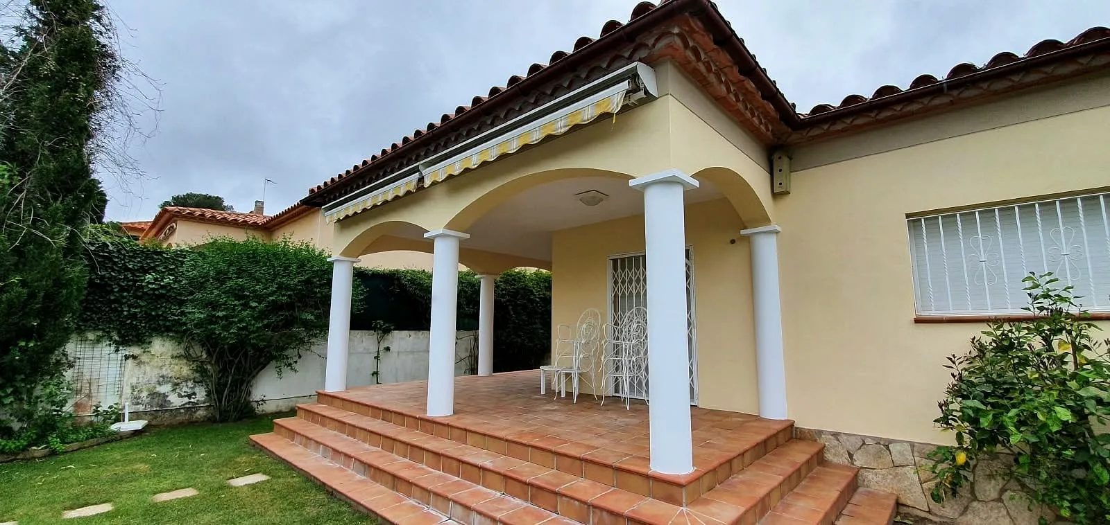 Porche con columnas y fachada en tono crema