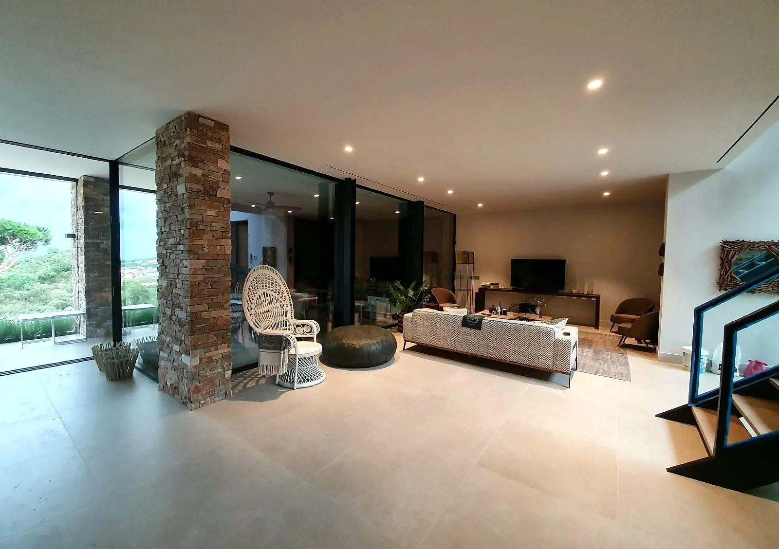 Salón amplio con ventanales y pilar de piedra
