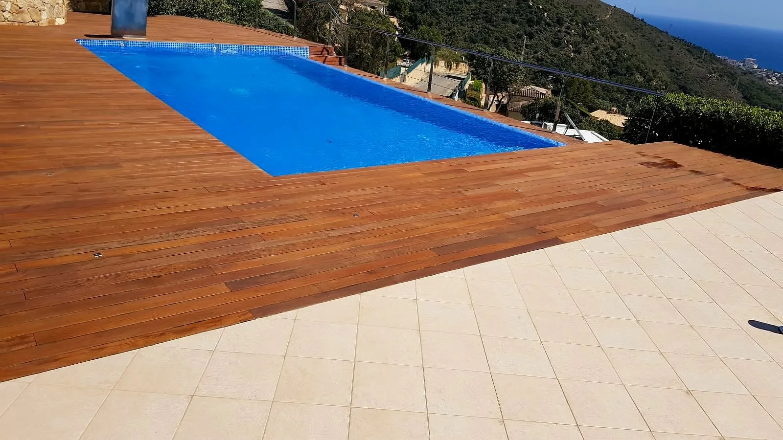 Tarima de madera y piscina con vistas al valle